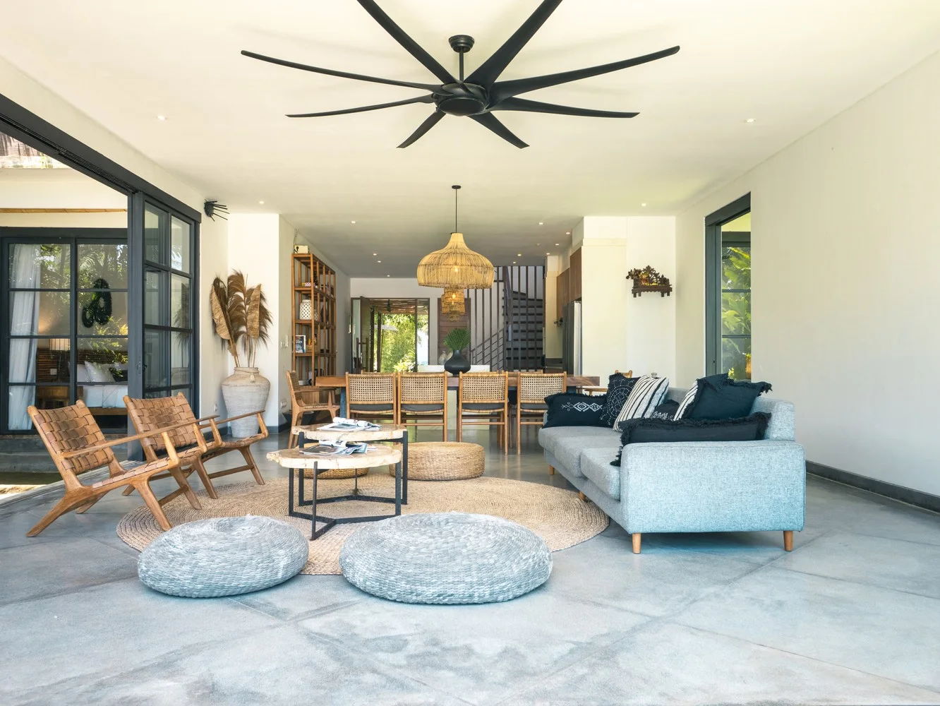 Shared living and dining area at Villa Lux Bali, with sofas, woven chairs and a long dining table